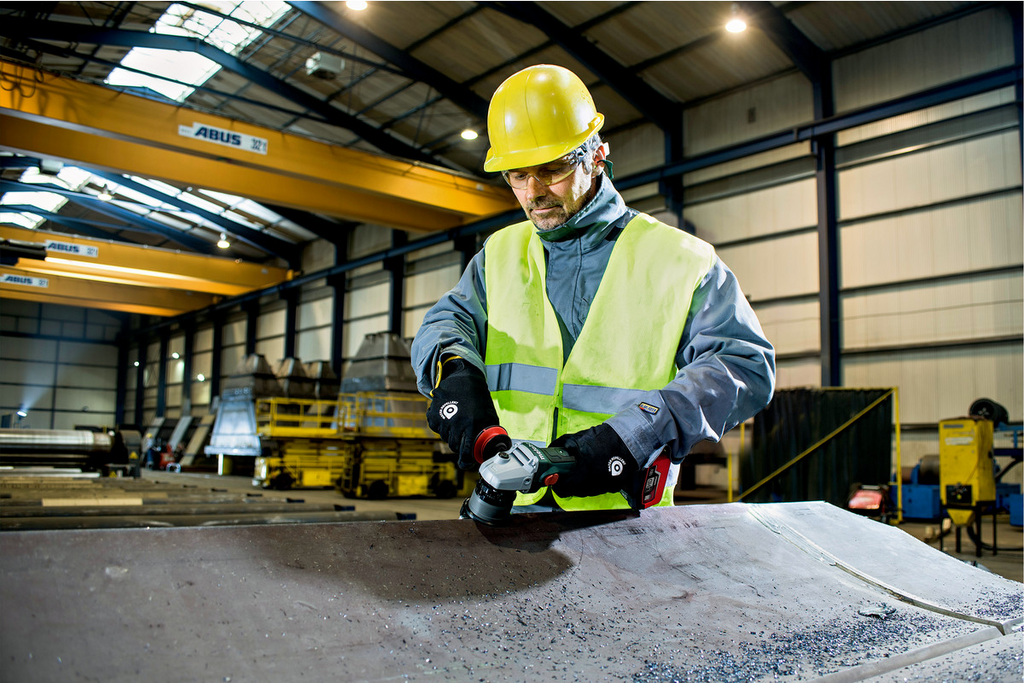 safety vest, hard hat, gloves, industrial setting, grinder