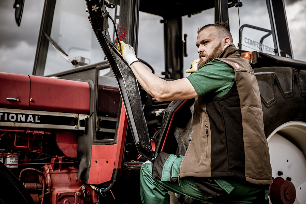 Traktor, Traktorkabine, Arbeiter, Arbeitshandschuhe, braune Weste
