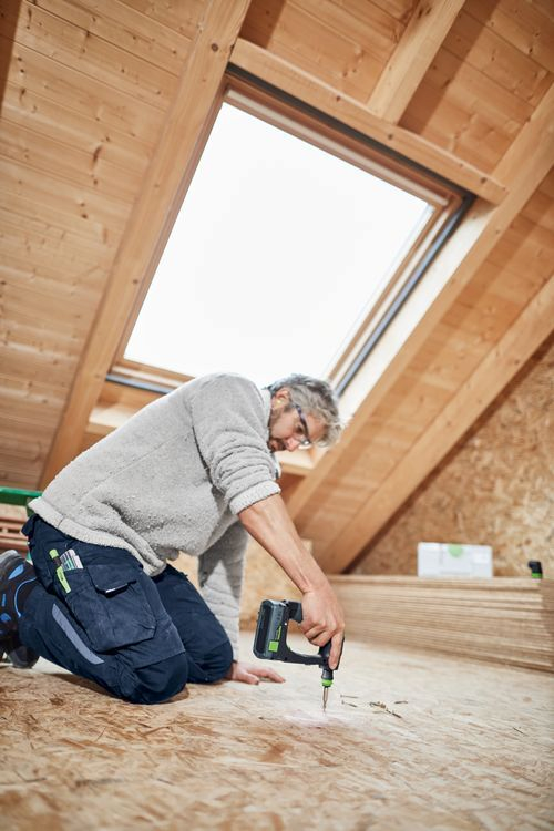 Kabeldurchpfosten?, Arbeitsloch, Holzbau, Bohrschrauber, MannBohrt im Dachboden